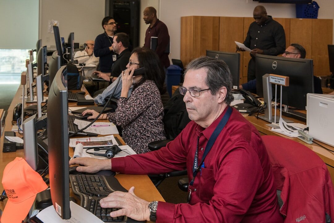 Cybersecurity professional monitoring multiple screens with security data in operations center
